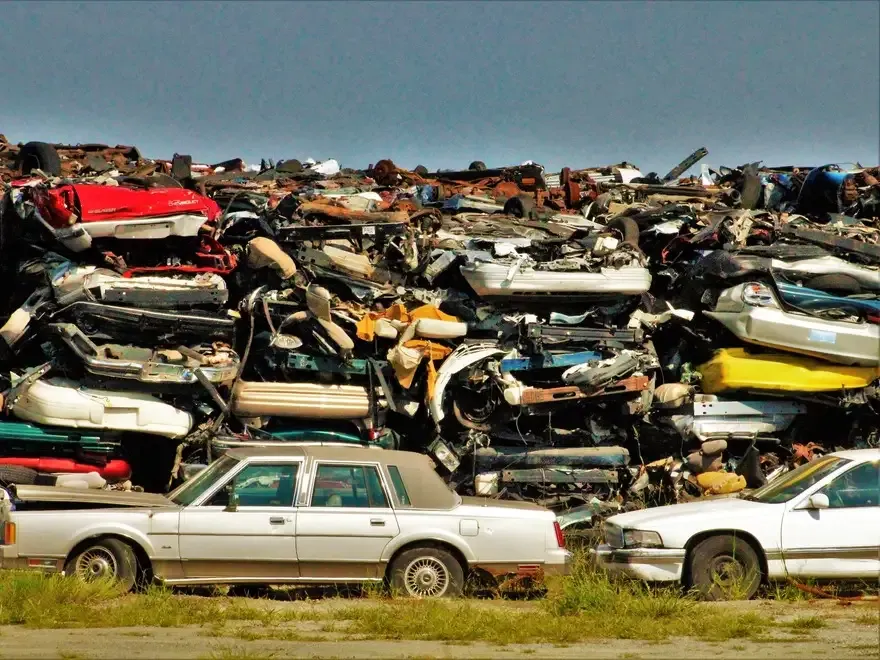 Scrap car bodies stacked in rows at the yard.