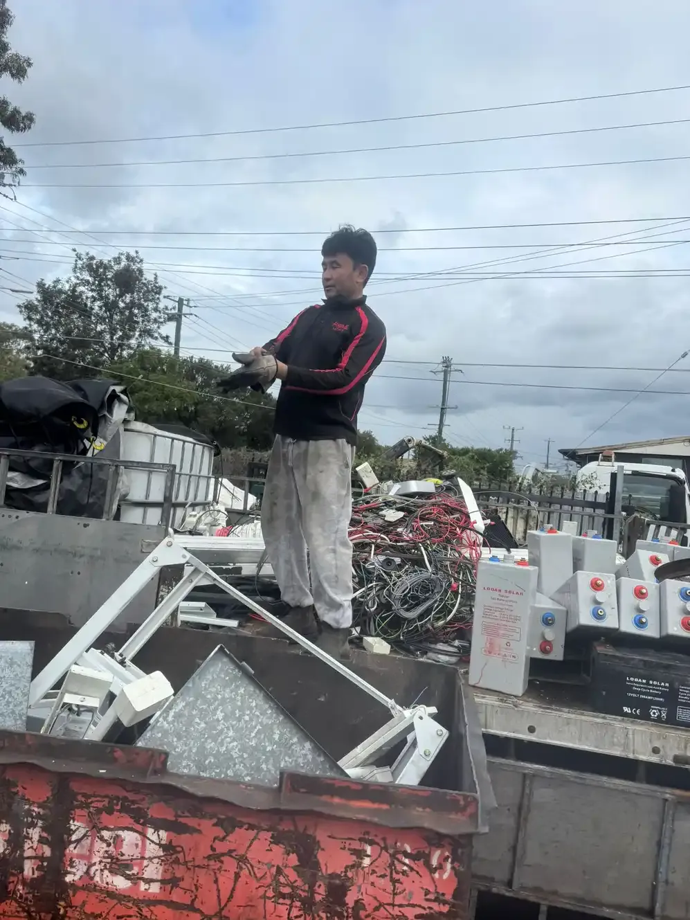 A worker sorting batteries and cable stripped from an e-waste job.